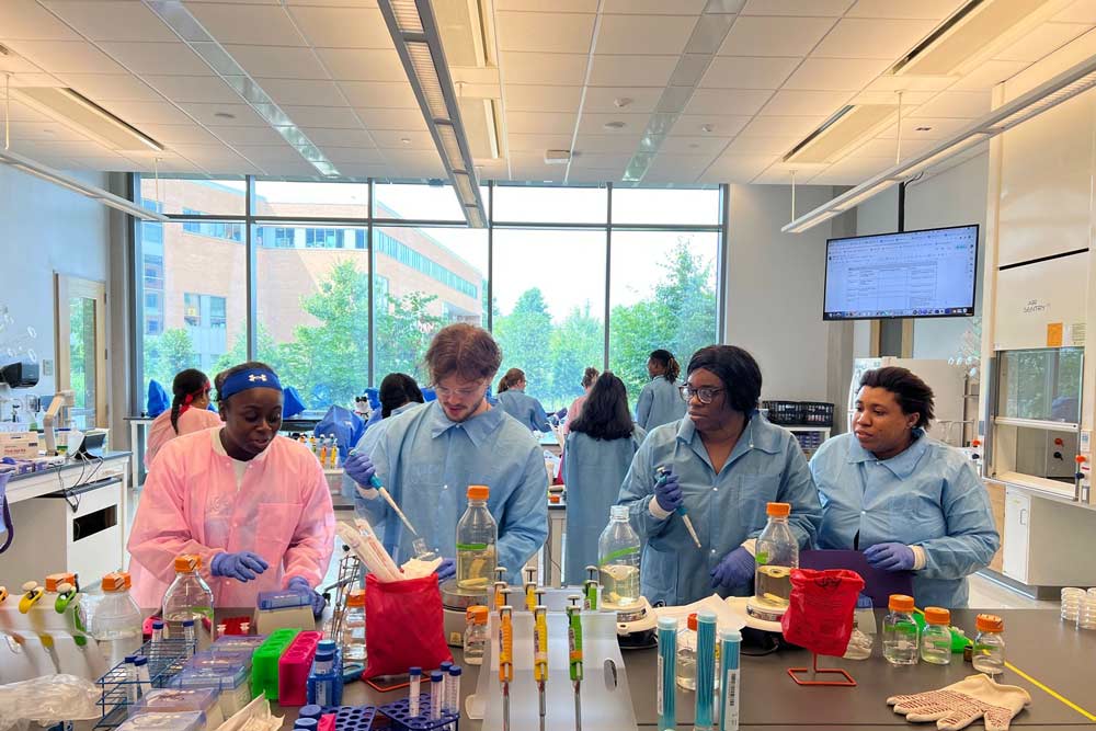 Four undergraduate students working in a lab